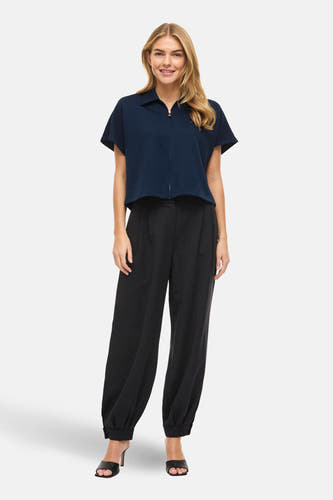 Blauwe sweater van VILA®, met korte mouwen en een ritssluiting, gecombineerd met een zwarte pantalon en hakken.