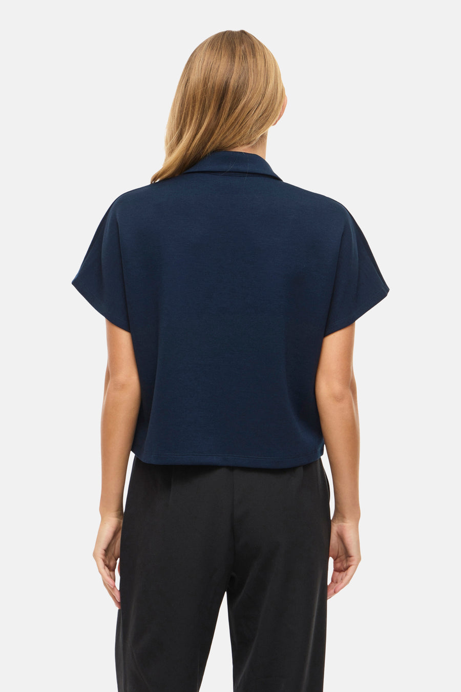Pull bleu de VILA, vu de dos, combiné avec un pantalon noir.
