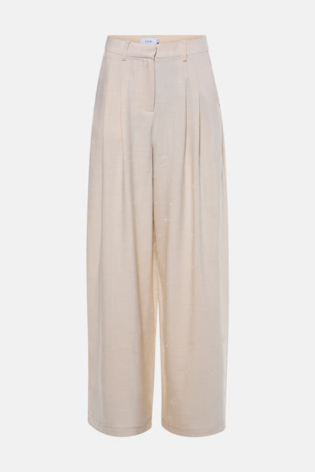 Pantalon beige de VILA® avec un motif floral subtil et des jambes larges, vu de dos.
