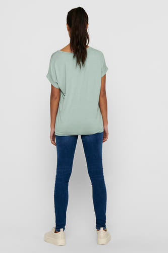 T-shirt vert de ONLY, avec des manches courtes et une coupe décontractée, associé à un jeans foncé et des baskets crème.