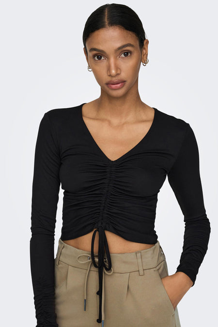 Pantalon chino beige de ONLY® à taille haute, poches et cordon de serrage, porté avec un crop top noir à manches longues.