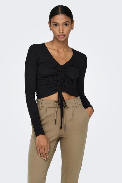 Pantalon chino brun de ONLY® avec taille à cordon, coupe ajustée et poches, porté avec un crop top noir à volants, vue de face