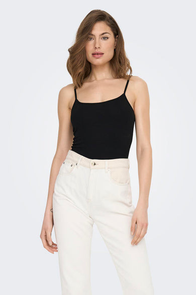 T-shirt noir avec des bandes de spaghetti de JDY, associé à un jean blanc.