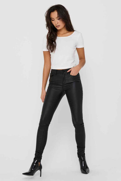 Pantalon noir de ONLY, avec un fini brillant, associé à une chemise blanche et des bottes noires.