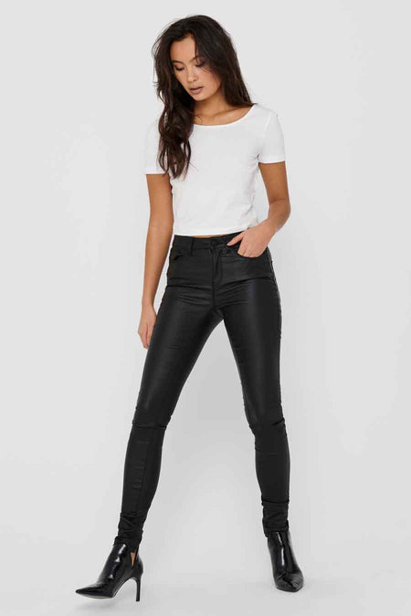 Pantalon noir de ONLY, avec un fini brillant, associé à une chemise blanche et des bottes noires.