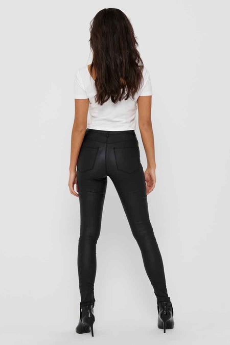 Pantalon noir de ONLY, montré sur le dos, associé à une chemise blanche et des bottes noires.