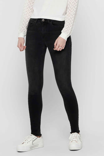 Jean skinny noir ONLY, avec un bord froncé, associé à une chemise blanche imprimée.