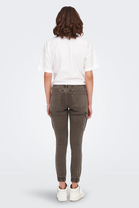 Pantalon brun d'ONLY, avec poches cargo, détaillé avec des ourlets élastiques, combiné avec un chemisier blanc et des baskets blanches.