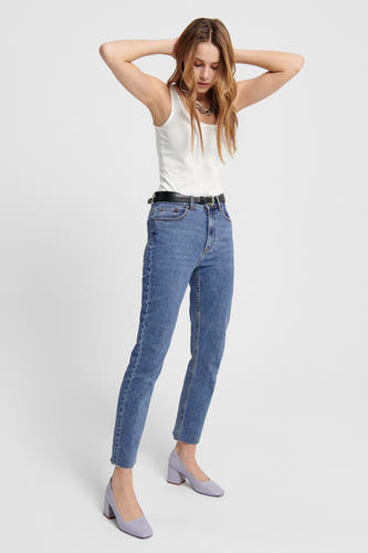 Jean mom bleu marine de ONLY, porté avec un haut blanc, une ceinture noire et des baskets violets.