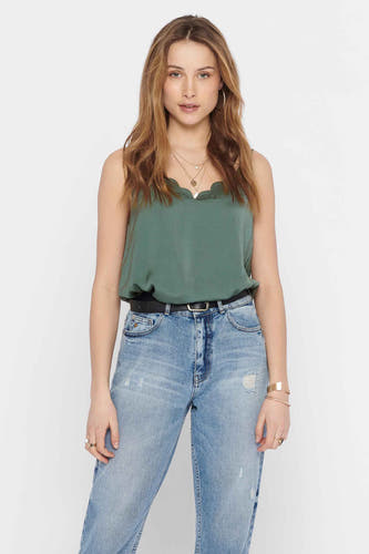 Blouse à manches longues sans col de ONLY, portée avec une ceinture noire et des jeans légèrement délavés.