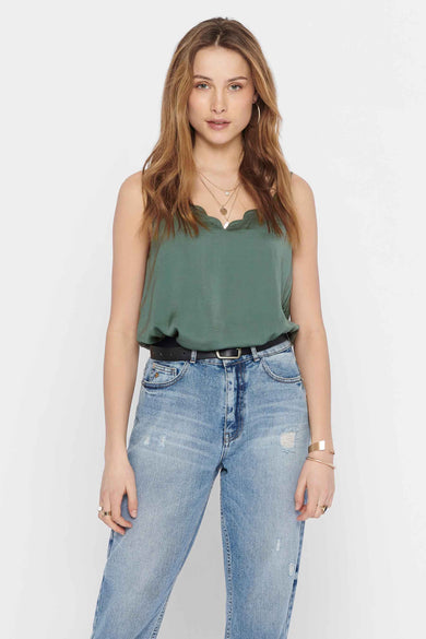 Blouse à manches longues sans col de ONLY, portée avec une ceinture noire et des jeans légèrement délavés.