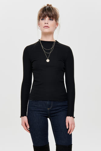 Pull noir à manches longues ONLY, avec avec structure en côtes et porté avec des jeans et des chaînes d'or.
