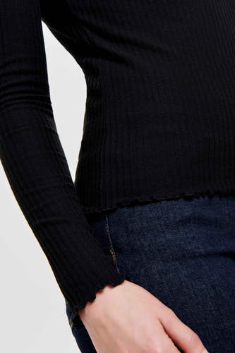 Pull noir à col rond de ONLY, avec structure en côtes et détails froncés, associé à un jean bleu marine.