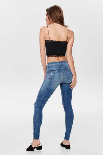 Vêtements ONLY noirs, avec des détails sur les bords, portés avec un jean destroy.