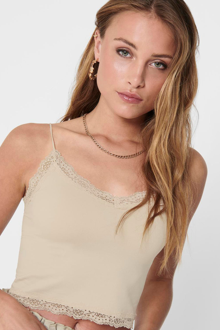 Crème ONLY, avec des détails de bordure sur le haut et le bas, combiné à une chaîne dorée et des boucles d'oreilles.