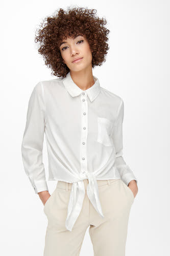 Chemise écru à manches longues d'ONLY, avec fermeture à boutons et détail de bouton sur le devant, combinée avec un pantalon beige.