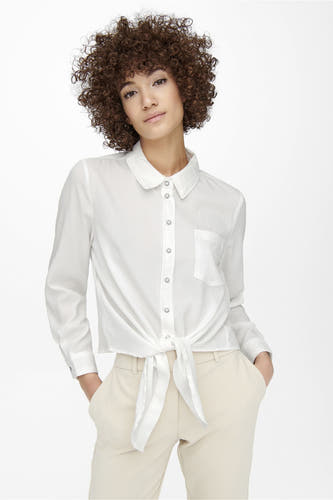 Chemise écru à manches longues d'ONLY, avec fermeture à boutons et détail en ruban en bas, combinée avec un pantalon de couleur crème.