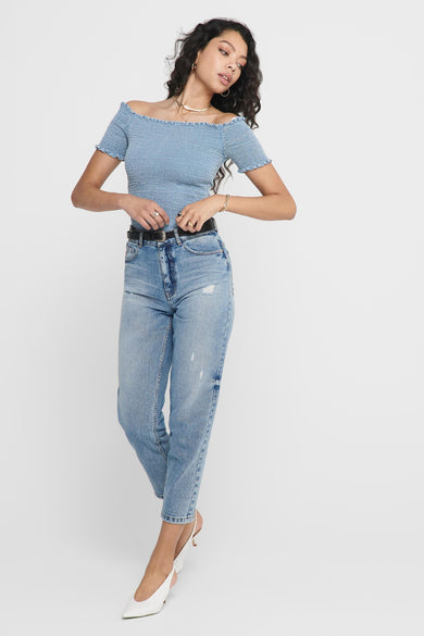 Top en denim bleu clair avec volants et épaulettes de ONLY®, porté avec un jean déchiré et des talons blancs, vue de face
