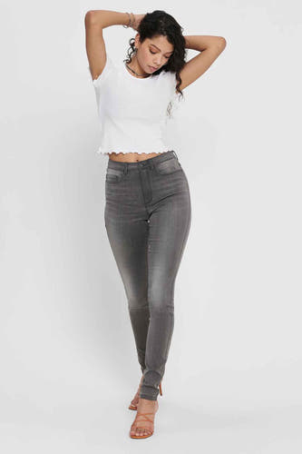 T-shirt blanc à manches courtes de ONLY, porté avec un jean gris et des sandales compensées.