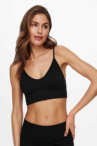 Manteau noir ONLY®, devant avec des bandes fines, porté avec un pantalon noir.