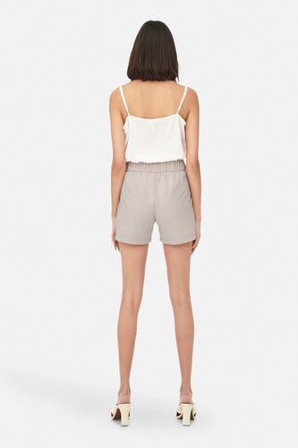 Short gris JDY, vu de l'rière avec avec une taille é et combiné avec une top blanche et des sandales beige.