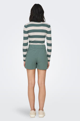 Groene short van JDY, gezien vanaf de achterkant, met een elastische tailleband en casual schoenen.
