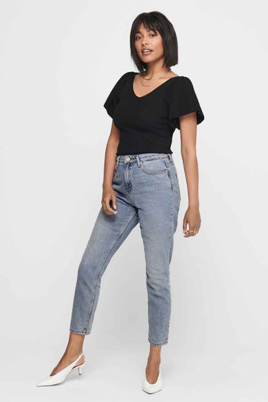 Zwart T-shirt met korte mouwen van ONLY, met een v-hals en gedragen met een blauwe jeans en witte hakken.
