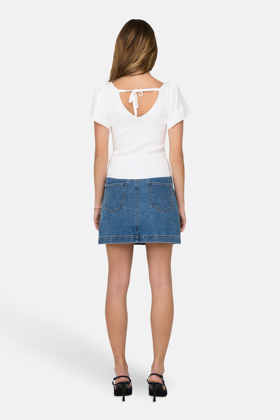 T-shirt blanc à manches courtes de ONLY, avec un détail rayé sur le dos, associé à une jupe en denim bleu et des bottines.