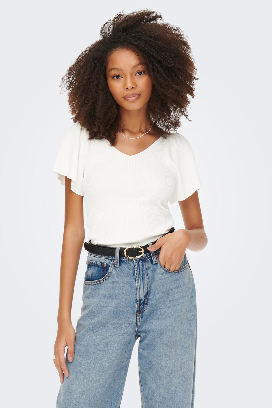 T-shirt blanc à manches courtes d'ONLY, avec une texture rayée, associé à des jeans et une ceinture noire.
