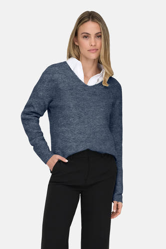 T-shirt bleu à col V d'ONLY® avec une blouse blanche en dessous et un pantalon noir.