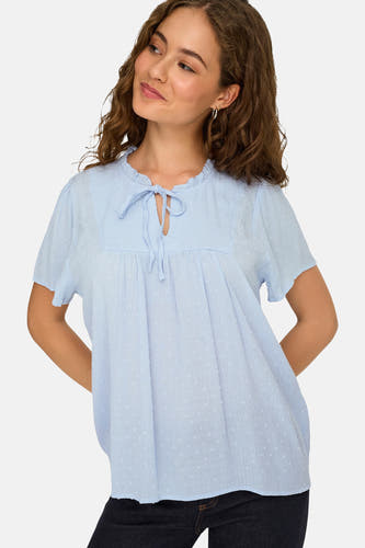 Chemisier bleu clair à manches courtes de JDY, avec tissu texturé, pois subtils, col à volants et détail de nœud.