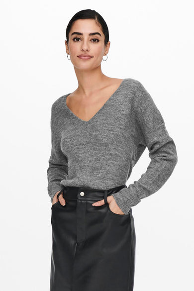 Sweat-shirt gris à col rond de JDY, avec une texture mélangée et porté avec une jupe noire et des bottes à talons hauts.