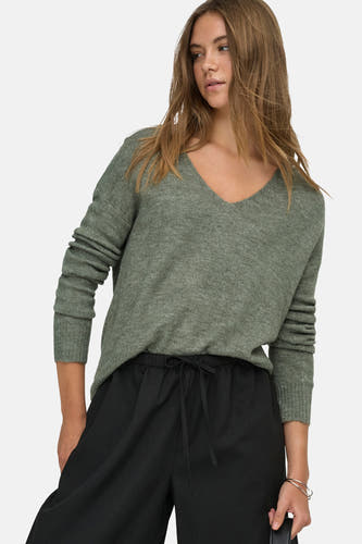 T-shirt vert avec col rond de JDY, porté avec un pantalon noir à cordon et un bracelet argenté.