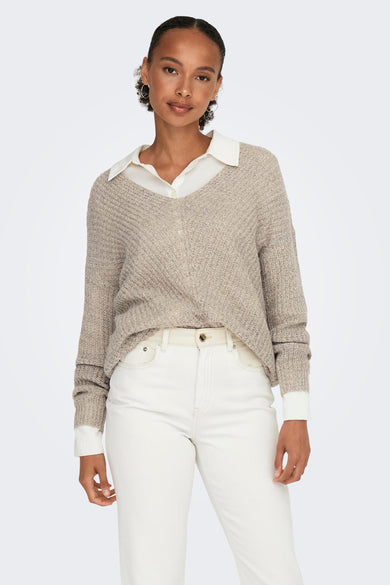 Pull à col V marron de JDY, associé à une chemise blanche et un jean blanc.