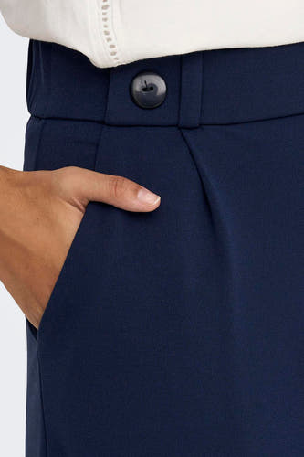 Pantalon de costume bleu JDY, avec une fermeture à boutons et une main dans la poche.