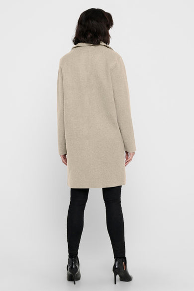 Manteau long beige ONLY, vu de dosrière avec avec pantalon noir et des bottes.