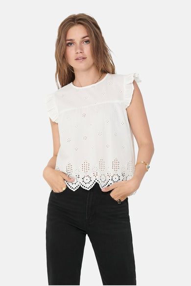 Blouse blanche d'ONLY, avec des détails brodés et associée à des jeans noirs.