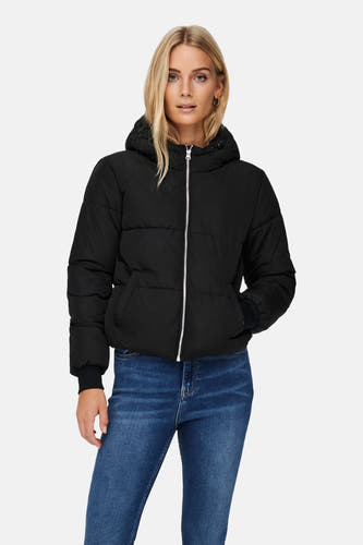 Manteau court noir de JDY avec capuche, associé à des jeans et des escarpins noirs.