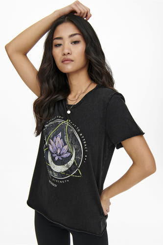 T-shirt noir de ONLY, avec imprimé de fleur de lotus, porté avec des chaînes.