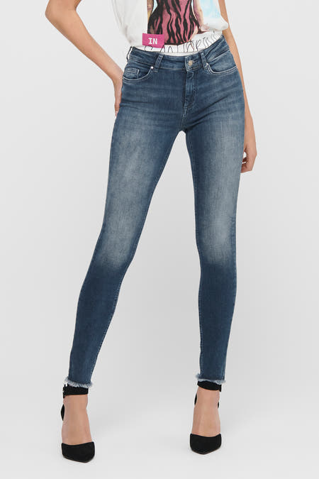 Jean skinny bleu marine d'ONLY, avec un bord froncé et associé à des talons noirs.