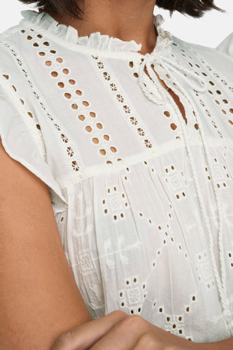 Witte blouse met ajourpatroon en koorddetails.
