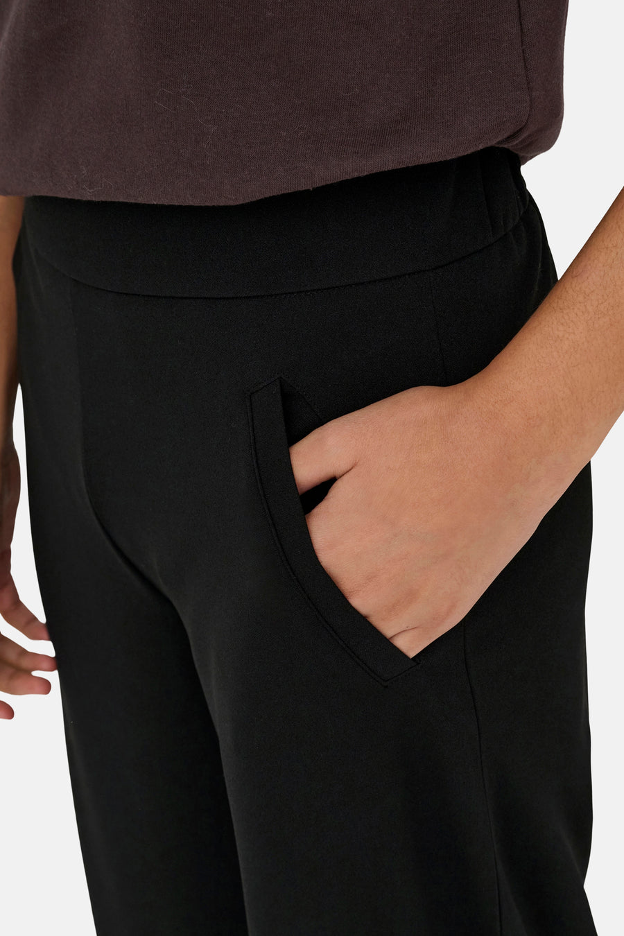 Pantalon de costume noir de JDY avec poche latérale insérée et une main dedans.
