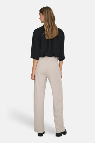 Pantalon de costume gris de JDY à jambes larges et taille élastique, porté par un mannequin avec un chemisier noir et des chaussures épaisses, vue arrière.
