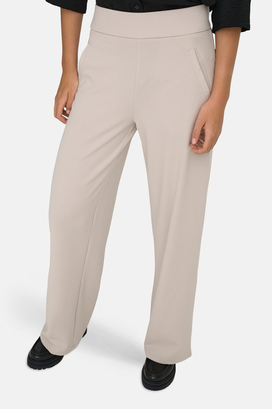 Pantalon de costume beige clair de JDY avec taille haute, jambes larges et poches italiennes, stylisé avec des mocassins noirs.