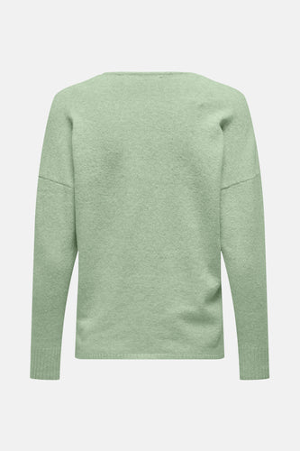 Lichtgroene gebreide trui met lange mouwen.
