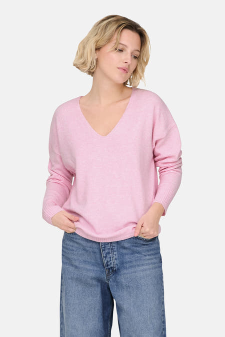 Pull à col V rose de ONLY, associé à des jeans larges et des chaussures noires.
