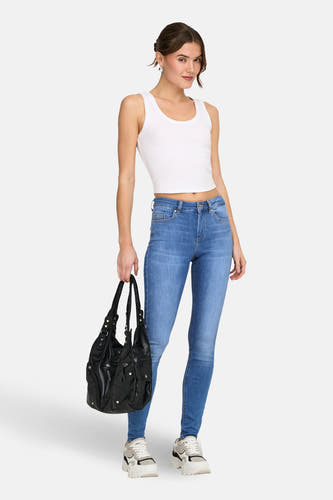 Jean skinny bleu de ONLY, porté avec un débardeur blanc, un sac noir et des baskets épaisses.