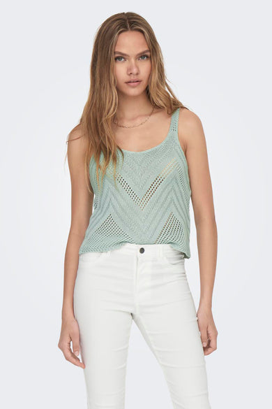 Débardeur vert tricoté avec motif en V ajouré de JDY, porté avec un jean blanc et un collier doré, vue de face
