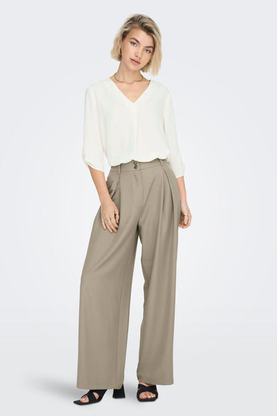 Blouse blanche de JDY, avec des manches longues et un col en V croisé.