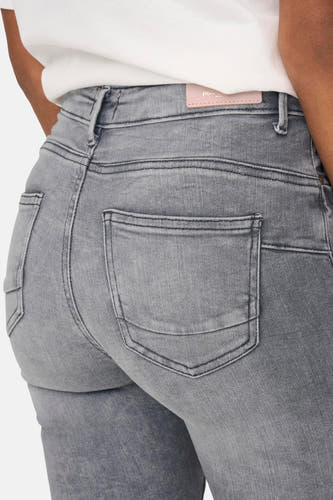 Jean skinny en denim gris clair d'ONLY, vue arrière avec des poches arrière et une chemise blanche.
